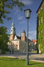 POLAND, Krakow, Road with lamppost and pedestrians leading up to Wawel Cathedral on Wawel Hill.