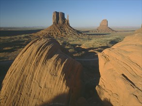 USA, Arizona, Monument Valley, Rock formations with a golden sunset glow on the valley with rocks