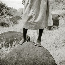 INDIA, Tamil Nadu, Near Vellamadam, A young Indian female orphan stands on a rock in a