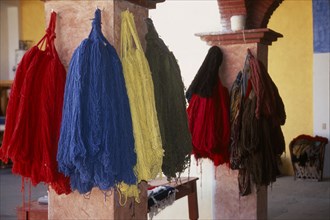 MEXICO, Oaxaca, Teotitlan del Valle. Different coloured thread handing on pillars in the weaving