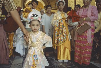 MYANMAR, Mandalay, Group all dressed up for ordination ceremony Mahamuni Paya. Young girl in