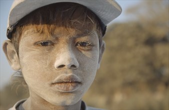 BURMA, Mandalay, "Portrait of a young boy worker in Mandalay dock with cement dust on his face,