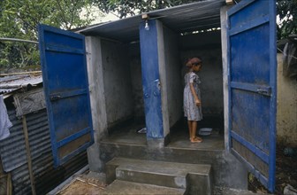 BANGLADESH, Dhaka, Young girl at latrines in slum area.