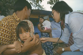 THAILAND, Khao Lak, A Burmese medic attends to a sick child caught in the Tsunami