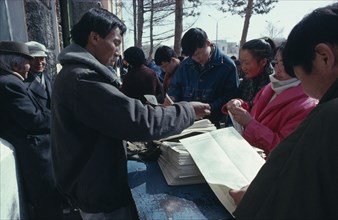 MONGOLIA, Ulaanbaatar, Newspaper vendor and customers.