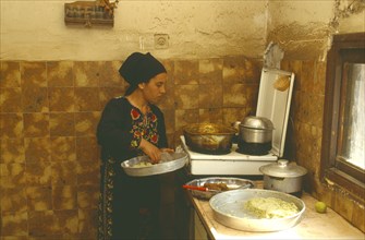 ISRAEL, Negev, Bedouin woman cooking in home.