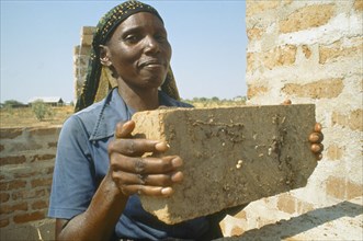 TANZANIA, Shinyanga, Woman in Mshikimano squatter settlement taught to make bricks for building her