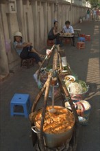 VIETNAM, South, Ho Chi Minh City, Sellers lined up against a wall selling food being from the