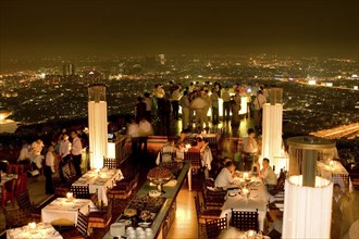 THAILAND, Bangkok, Sorocco Restaurant. People dining at tables with the Bangkok Skyline in the