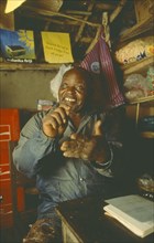 MALAWI, Mulanje, Chikondano Village. Disabled male shopkeeper sat in his small shop. Able to run