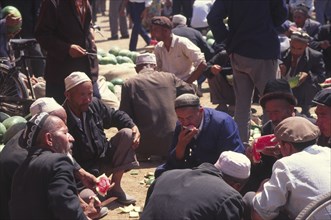 CHINA, Xinjiang Province, Kashgar, Market Vendors eating water melon