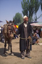 CHINA, Xinjiang Province, Kashgar, Tajik men with a horse for sale