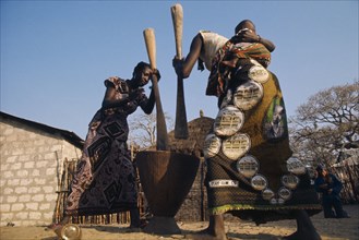 SENEGAL, Agriculture, "Women pounding maize, one carrying baby on her back."