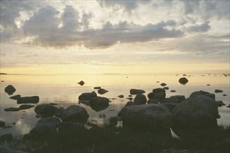 ESTONIA, Baltic Coast, Sunset over rocks and sea during the longest day of the year.
