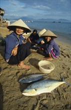 VIETNAM, Nha Trang, Woman with fish at Cau Dau fishing village at the South end of the beach.