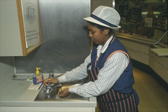ENVIRONMENT, Hygiene, Washing, Supermarket assistant washing hands at basin of delicatessen counter