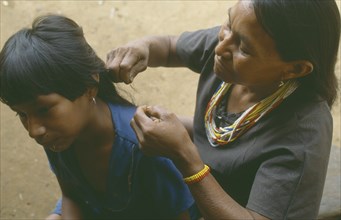 COLOMBIA, Amazonas, Santa Isabel, Macuna Indian woman checking her daughter’s hair for lice.