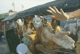THAILAND, Bangkok, "People in a tuk tuk covered in mud, celebrating the Songkhran Festival. Thai