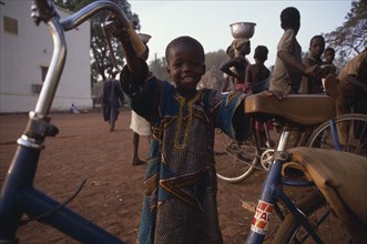 MALI, Sikasso, Little boy with bicycle.