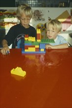 CHILDREN, Play, Children playing with brightly coloured building bricks.