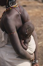 SENEGAL, Children, Carrying, "Baby carried in sling on mothers back, both wearing bead jewellery."