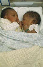 CHILDREN, Twins, One week old African twins in cot together and communicating.