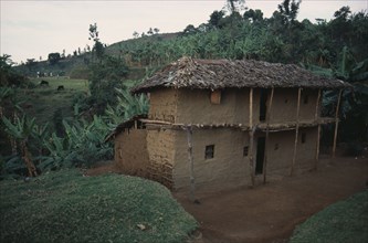 UGANDA, Traditional Housing, Two storey mud brick house with thatched roof in rural area near Mbale