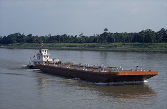 BRAZIL, Amazon, Barge on the Amazon River being pushed upstream towards Manaus.