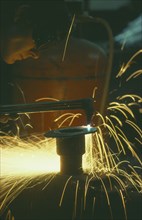 ENGLAND, Dorset, Engineering, Man wearing protective goggles while welding with sparks flying.