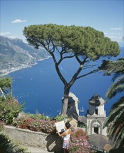 ITALY, Campania, Ravello, "Villa Rufolo, view from gardens to Maiori, Salerno. Tree in the