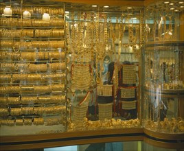 UAE, Dubai, Yellow Gold displayed in shop window. Different types of jewellery including necklaces