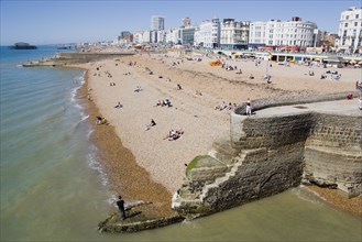 ENGLAND, East Sussex, Brighton, The beach and seafront with flint groyne in the foreground seen