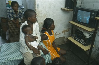 ANGOLA, Luanda, Bairro of Cacuoca.  Fifteen year old Maria Lydia at home watching television with