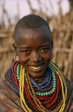 UGANDA, Karamoja District, Portrait of Karamojong woman wearing multiple coloured bead necklaces.
