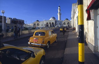 ERITREA, Asmara, Streetscene with mosque and taxis.