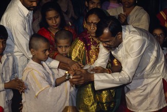 INDIA, Gujarat, Ahmedabad, Young boy at his Upanayana Brahmin thread ceremony.