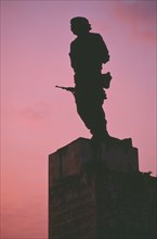 CUBA, Santa Clara, Plaza de la Revolution.  Statue of Che Guevara silhouetted at sunset.