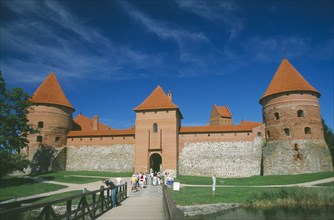LITHUANIA, Trakai, Visitors on bridge to entrance of Trakai Castle.