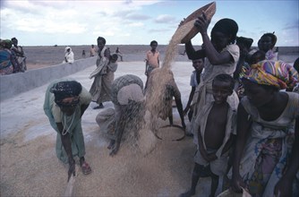 SOMALIA, Farming, Settled nomad women and children winnowing rice crop.