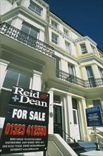 ENGLAND, East Sussex, Eastbourne, Real Estate For Sale signs outside Regency style properties.