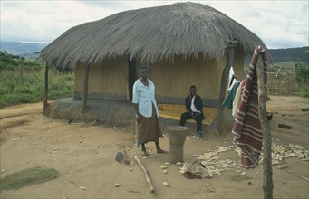 MALAWI, Lumbe, Couple outside thatched home in Wilsan village.