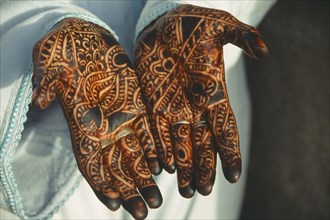 MOROCCO, Fes, Cropped view of woman’s hands with palms decorated with intricate henna design.