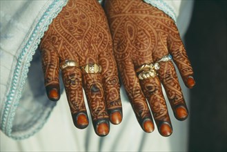 MOROCCO, Fes, Cropped view of woman’s hands with backs decorated with intricate henna design.