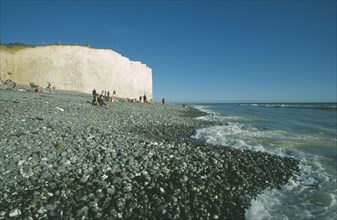 ENGLAND, East Sussex, Birling Gap, Occupied peeble beach with waves lapping and section of cliff