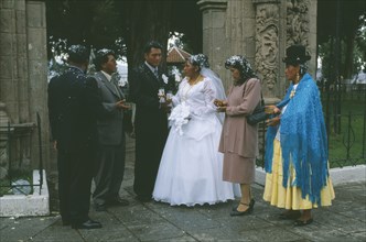 BOLIVIA, La Paz, "Wedding in El Monticulo. Bride, Groom and guests standing under archway"