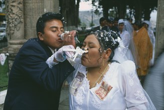BOLIVIA, La Paz, Wedding in El Monticulo. Bride and Groom interlocking arms and drinking. Money