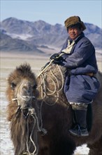 MONGOLIA, Hovd Province, People, Mongolian nomad returning to camp on camel.
