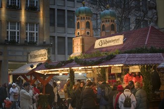 GERMANY, Bavaria, Munich, People at a Gluhwein stall at the Christmas Market.