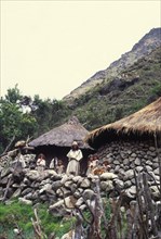 COLOMBIA, Santa Marta, Sierra Nevada , "Ica Indigenous family, with home in background."