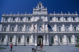 ITALY, Sicily, Catania, Classical architecture of the Gymnasium exterior with people on bicycles in